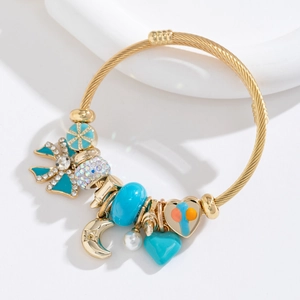 Bracelet ajustable en acier doré avec charms papillon bleu en cristal et cœurs variés