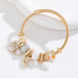 Bracelet torsadé doré réglable avec breloques cœur, lune et perles sur fond blanc pur