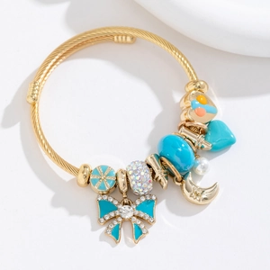 Détail du bracelet câble doré avec breloque papillon bleu et perles fantaisie