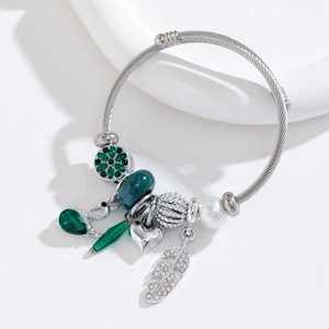 Détail du bracelet en câble d'acier torsadé avec cœur en cristal vert et perles