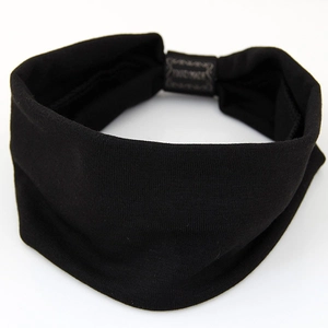 Elastic wide knit yoga headband in black featuring a decorative Hand Made woven label