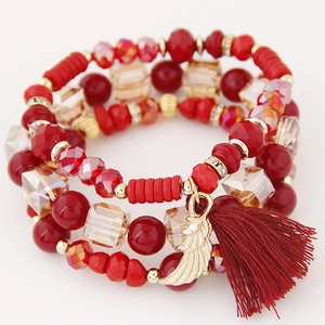 Multilayer red crystal beaded bracelet featuring gold wing charm and fringe tassel