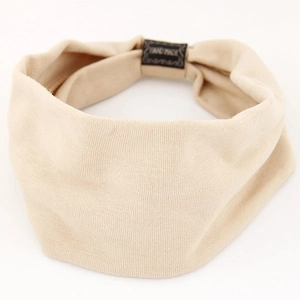 Close-up of beige elastic yoga headband with knit texture and handmade fabric label