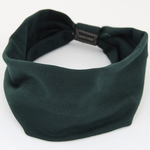 Close-up of elastic cotton yoga headband in dark green with a Hand Made fabric label