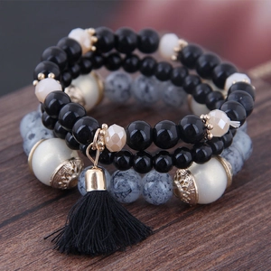 Bohemian multilayer beaded bracelet with black tassel and marble stone beads on wood