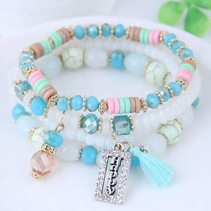 Bracelet bohème multicouche perlé avec accents turquoise et pompon en soie bleue