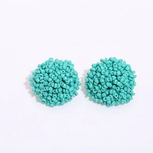 Close-up of handmade turquoise seed bead stud earrings in a cluster dome design