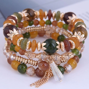 Close-up of bohemian multilayer beaded bracelet with tassels and crystal pendant detail