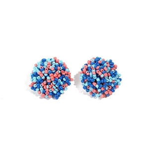 Close-up of handmade bohemian beadwork earrings with vibrant blue and pink floral pattern