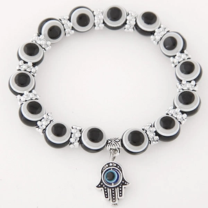 Macro shot of Hamsa Hand charm with evil eye beads and silver engraved spacers