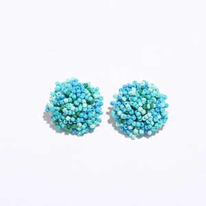 Detailed close-up of handmade blue and mint green seed bead cluster stud earrings