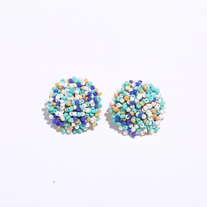 Detail view of round handmade beaded stud earrings with bohemian colorful bead patterns