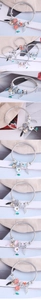 Macro detail of silver beaded bracelet featuring floral charms and star wing pendants
