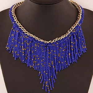 Bohemian multilayer fringe necklace with dark blue beads and gold chains on a mannequin