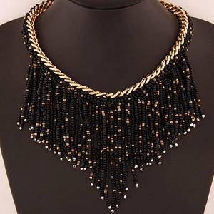Bohemian multi-layer necklace with gold chains and black beaded tassel fringe on a neck display
