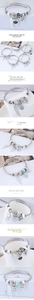 Detailed close-up of owl and wing charms on a multi-element steel cable bracelet