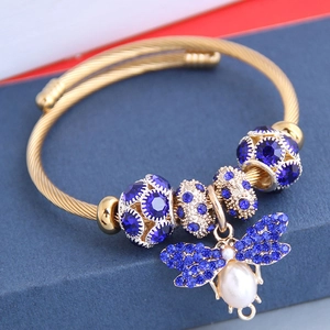 Bracelet jonc bohème doré en acier avec charm abeille, strass bleus et perle blanche