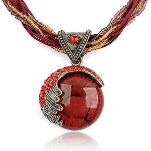 Detail of bohemian red gemstone necklace with bronze feathers and beaded cord