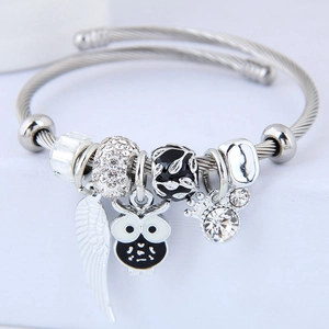 Stainless steel beaded bangle featuring owl and wing charms in a chic European style