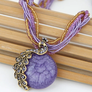 Bohemian retro peacock pendant necklace with purple resin stone and crystal details