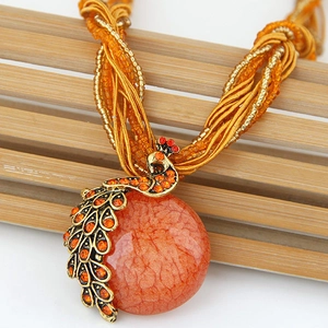 Bohemian peacock pendant necklace with orange beads and sparkling rhinestones