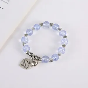 Bohemian style beaded bracelet with light blue beads, sunflower spacer, and heart pendant