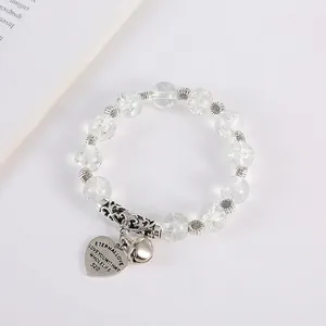 Detail of beaded bracelet featuring cracked crystals and eternal love heart pendant