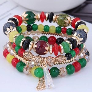 Close-up of bohemian layered beaded bracelets with colorful crystal charms and gold beads