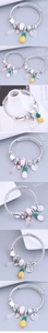 Detail of silver spiral bangle with enamel pineapple, crystal heart, and diamond charms