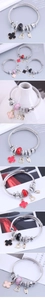 Detailed close-up of wire bangle featuring clover charms and a crystal crown pendant