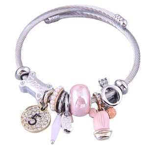 Bracelet jonc torsadé argenté avec perles roses et charms couronne sur fond blanc