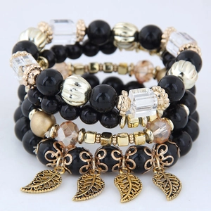 Detail of multi-layer beaded bracelets with gold leaf charms and black glass beads
