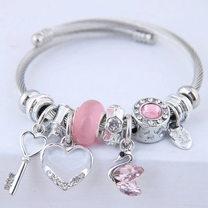 Bracciale con perline di cristallo rosa e ciondoli a cuore e cigno su sfondo bianco