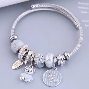 Silver charm bracelet with bear pendant, Eiffel Tower, and LOVE charms on steel cable