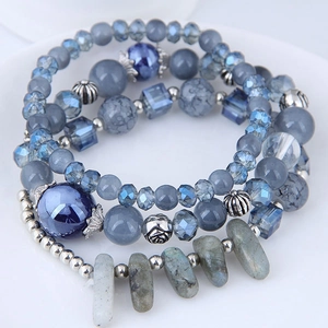 Bracelet multicouche bohème avec pierres œil de chat et breloques en cristal sur plat blanc