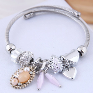 Bohemian silver wire bracelet with heart charms and pink gemstone pendant on white background