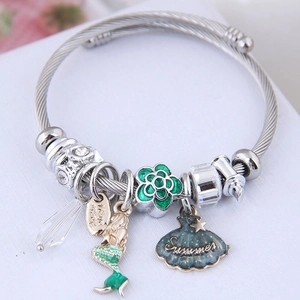 Bracelet à breloques argenté avec sirène et coquillage sur fond blanc épuré