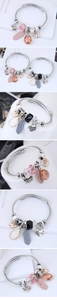 Detail of silver mesh charm bracelet with heart pendant, crystals, and enamel butterfly
