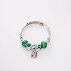 Bohemian silver twisted wire bracelet featuring green glass beads and dreamcatcher charm