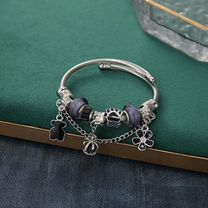 Adjustable steel bangle with purple beads and black bear, crown, flower charms