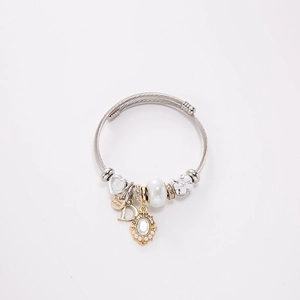 Detailed macro view of beaded steel wire bracelet with pearls and charms on white background