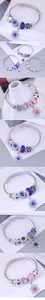 Macro detail of snowflake pendant and colorful glass beads on braided wire bracelet