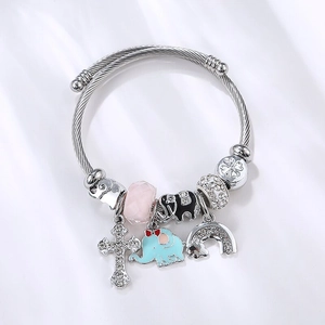 Steel cable bracelet featuring elephant, cross, and rainbow charms with pink stone bead