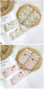 Close-up of ice silk cooling sleeves with floral daisy and tropical fruit print patterns