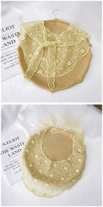 Detail of light yellow lace scarf with floral embroidery and wavy edges in a vintage style