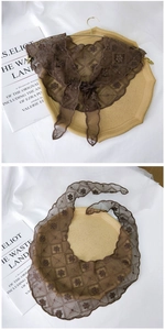 Detailed close-up of brown floral lace embroidery on a vintage style triangular scarf