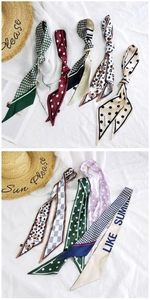 Detailed close-up of multiple printed narrow silk scarves with dots and houndstooth patterns