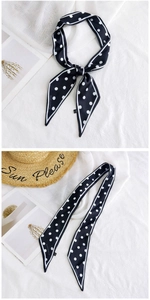 Detailed view of polka dot long silk scarf with white borders and brand logo detail