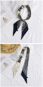 Close-up of narrow silk-like scarf with houndstooth pattern and Like Rain text design