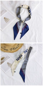 Close-up of narrow houndstooth silk scarf with Like Rain print and summer vacation props
